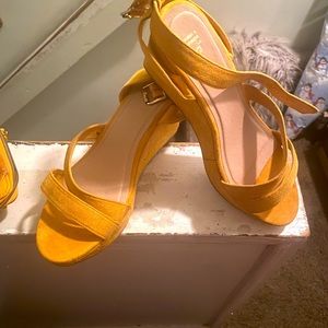 A pair of wedge yellow sandals with matching purse